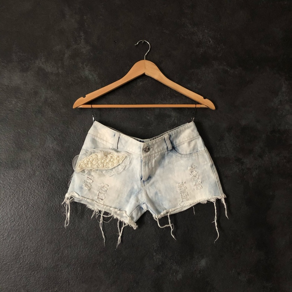 Light washed distressed denim shorts with pearl